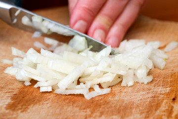 Chopping onions with precision on a wooden cutting board