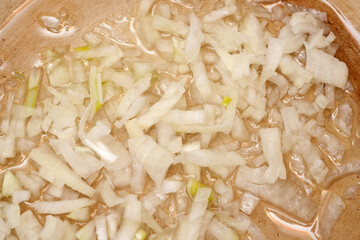 Chopped onions sizzling in a warmpan, creating a savory aroma