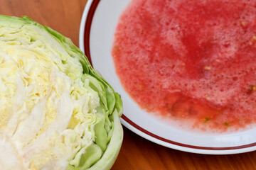 Fresh cabbage beside vibrant watermelon juice on wooden table
