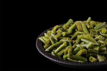 Frying green beans with spices on black background. Text space	