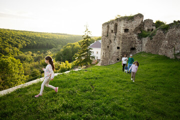 Family exploring scenic ruins surrounded by lush greenery during a sunny day