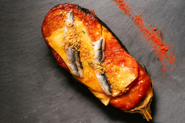 Baked Eggplant with Tomato Sauce, Cheese, Anchovies, and Bread Crumbs on Slate Background