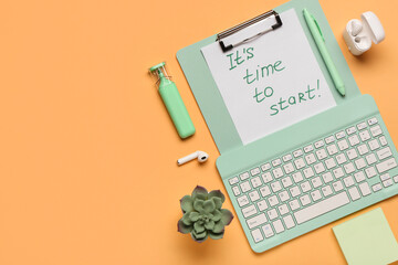 Clipboard with text IT'S TIME TO START, earphones and keyboard on orange background.Top view