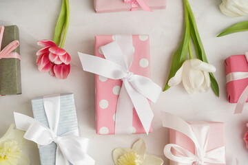Gift boxes with beautiful tulips and daffodil flowers on white background