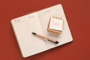 Open notebook with to do list and pen on brown background. Time management concept. Top view