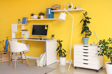 Interior of teenager's room with workplace, plants and shelves
