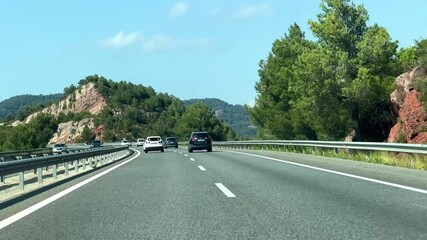 A car driving on a highway through a scenic mountain landscape. - Powered by Adobe