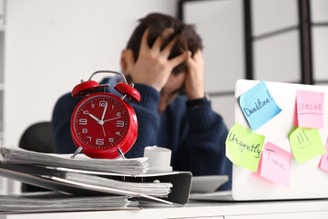 Alarm clock and businessman in office. Time management concept