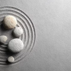 Fototapete Rund Smooth, light-grey sand forms concentric circles around several off-white and beige stones in a minimalist zen garden design © NurulSinta