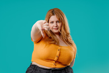 Plus Size Woman With Dislike. Grimacing Condemning Curvy Lady Shows Thumbs-Down