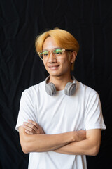 Studio portrait of young gay man with septum piercing ring and headphones