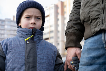 Father and son walking down on sidewalk together. Portrait of a handsome middle-aged man with...