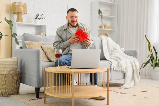 Young man using laptop for chatting with girlfriend at home. Online dating