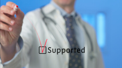 Medical professional ticking a checkbox with the word supported written next to it, using a red...