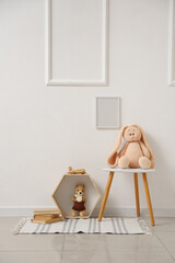 Interior of children's room with blank frame, table and toys