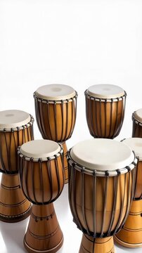 Seven light brown wooden goblet drums with tan tops arranged in a semi-circle formation on a white surface creating a musical visual display.