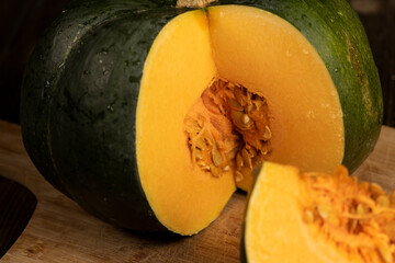 cut orange ripe pumpkin for cooking, cut into pieces sweet pumpkin in the kitchen, close up