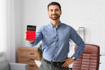 Smiling businessman with red modern calculator in office