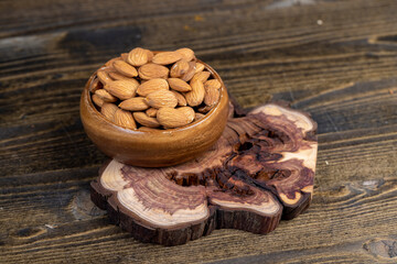 a lot of almonds scattered on a table, edible delicious and crunchy brown almonds