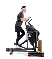 Sporty young man with sports equipment training on modern exercising bike against white background