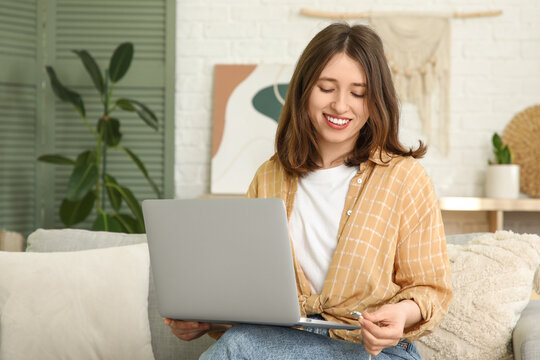 Young woman unplugging charger from laptop at home. National Day of Unplugging