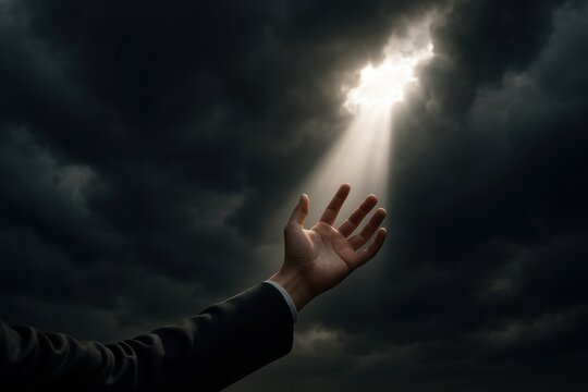 Hope shines through dark clouds as a hand reaches towards the light in a moment of realization and relief