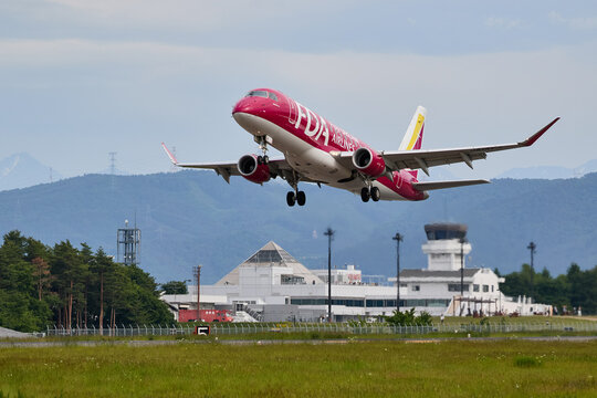 2025年6月7日、長野県松本市の信州まつもと空港、離陸するFDAのエンブラエル E-175 14号機 ワインレッド