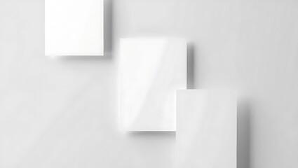 Minimalist presentation of three white rectangles on a white background with soft shadows and light