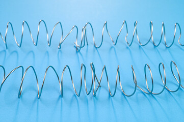 Coiled steel wires on a blue background.