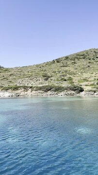  serene coastal landscape featuring clear blue water, a rocky shoreline. Knidos, Turkiye
