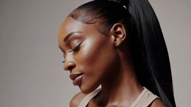 A light-skinned Black woman with long hair extensions, wearing a beige tank top, poses for a photoshoot for her Instagram profile picture. Her hair is styled in a ponytail
