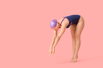 Diving female swimmer on pink  background