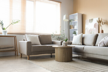 Interior of living room with grey sofas, table and shelf unit