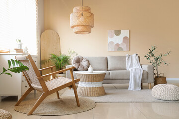 Interior of living room with grey sofa, armchair and rattan table
