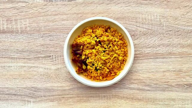 A vibrant and colorful bowl of delicious yellow rice, showcasing a variety of flavorful ingredients and spices