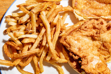 Close up of a fried chicken sandwich and fries with a shallow depth of field and copy space