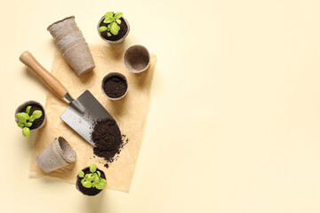 Gardening shovel with soil, plant seedlings and peat pots on color background © Pixel-Shot