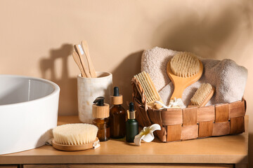 Bottles of cosmetic products and bath supplies on wooden table near sink