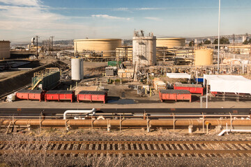 Oil refinery in Northern California at sunrise with storage tanks, pipelines and railroad tracks