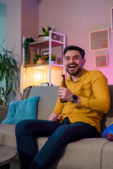 Man enjoying a drink in a cozy modern living room at night