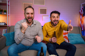 Friends celebrate together while watching sports at home