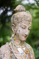 The head of the old female statue is covered with pearl necklaces.
