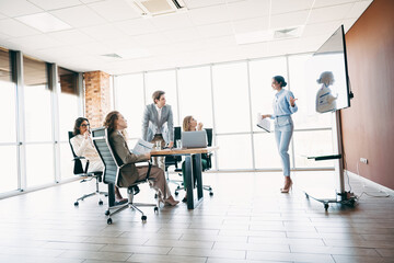 Professional Team Collaborating in a Modern Office Setting with Corporate Presentation and Strategic Planning