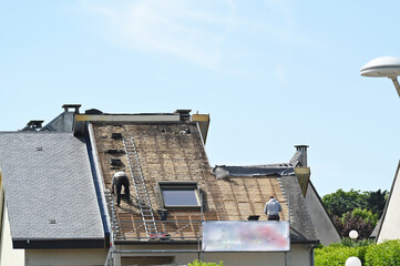 ouvrier couvreur sur un toit d'habitation en rénovation