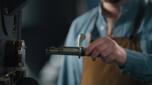 Man smell fresh coffee beans check quality roster machine aroma smelling Caucasian male enjoy flavor smiling guy barista small business owner control roasting process caffeine industry working factory