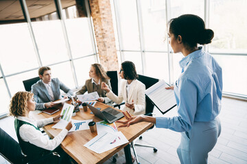 Business professionals collaborating in a modern office workspace discussing ideas during a team...
