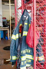 Firefighter jackets hanging on a rack at a fire station