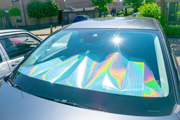 Reflection of the sun in aluminium foil under a car window produces a spectrum of bright rainbow colours due to light refraction.