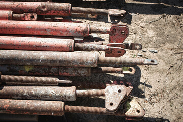 Metal scaffolding poles stacked on construction site during daylight hours