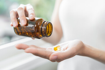 Dietary supplement concept, happy asian young woman hand holding fish oil pills, drugs medical...
